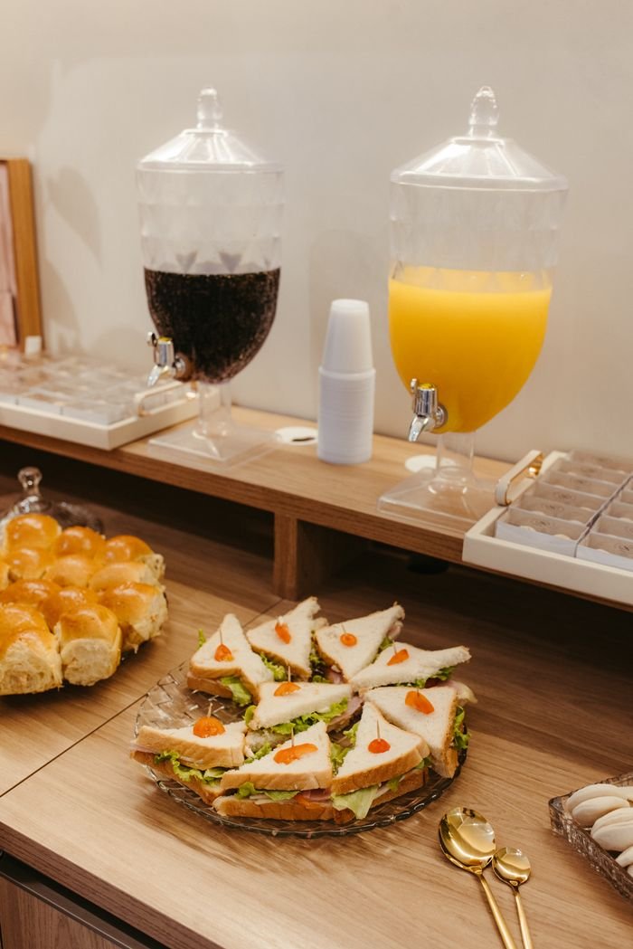 Appetizing breakfast buffet setup with drinks and sandwiches ready to serve.